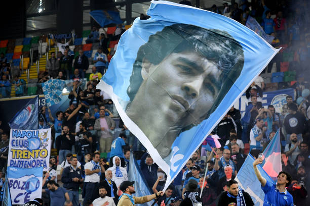 CĐV Napoli mang cờ in hình Maradona ăn mừng chức vô địch Serie A đầu tiên của Napoli sau 33 năm