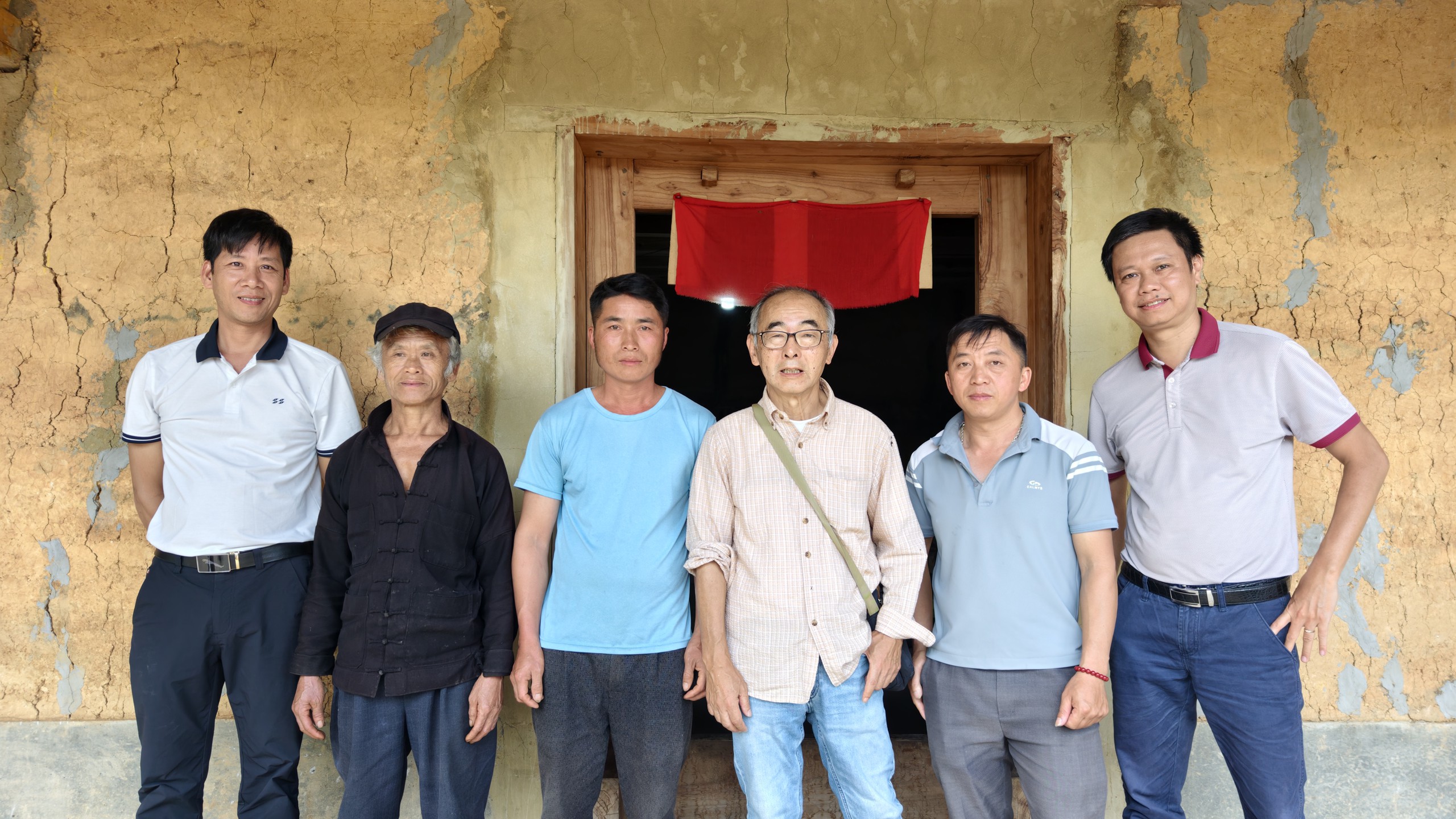 Một gia đình ở Giàng Xì Tủng đón ông Yasushi Ogura (giữa) và phóng viên báo Thể thao và Văn hóa (ngoài cùng bên phải) đến thăm nhà. Ảnh: Huy Thông