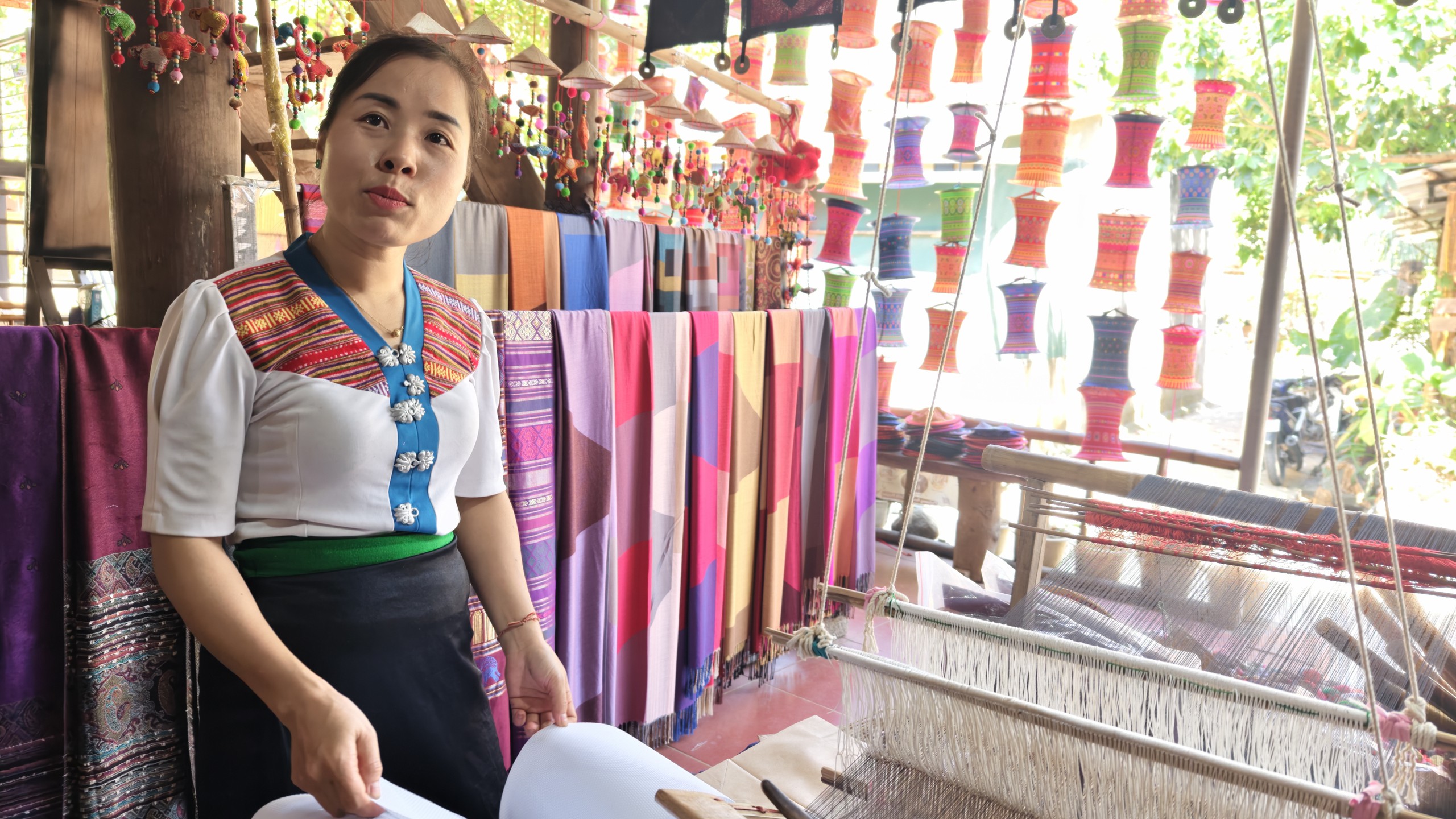 Cụ Hà Thị Nhân hướng dẫn chị Nhân Ái - du khách đến từ TP.HCM dệt vải. Ảnh: Huy Thông - ảnh 3