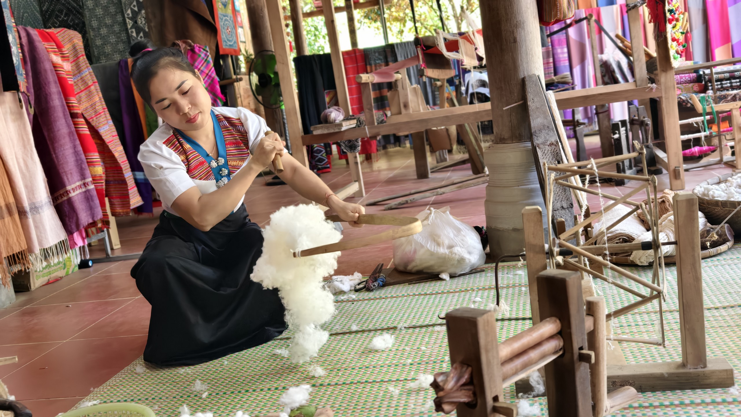 Cụ Hà Thị Nhân hướng dẫn chị Nhân Ái - du khách đến từ TP.HCM dệt vải. Ảnh: Huy Thông - ảnh 6