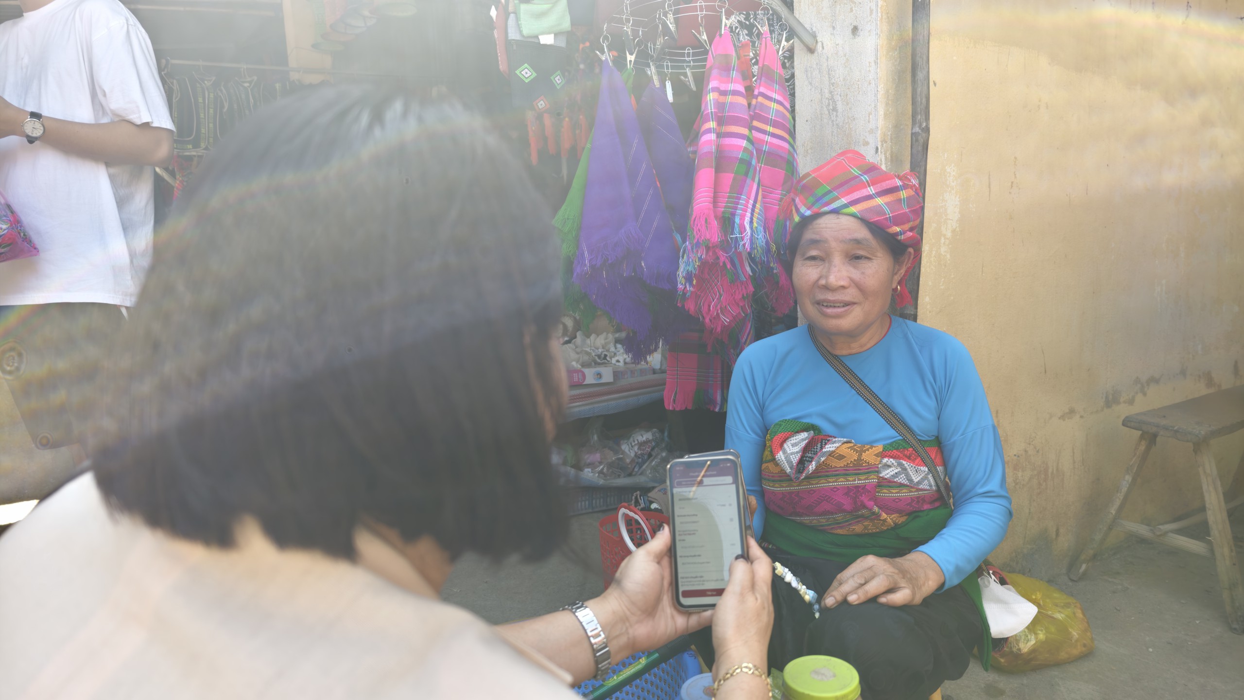 Bà Bùi Thị Hoa quét mã QR thanh toán cho người dân sau khi mua hàng. Ảnh: Huy Thông