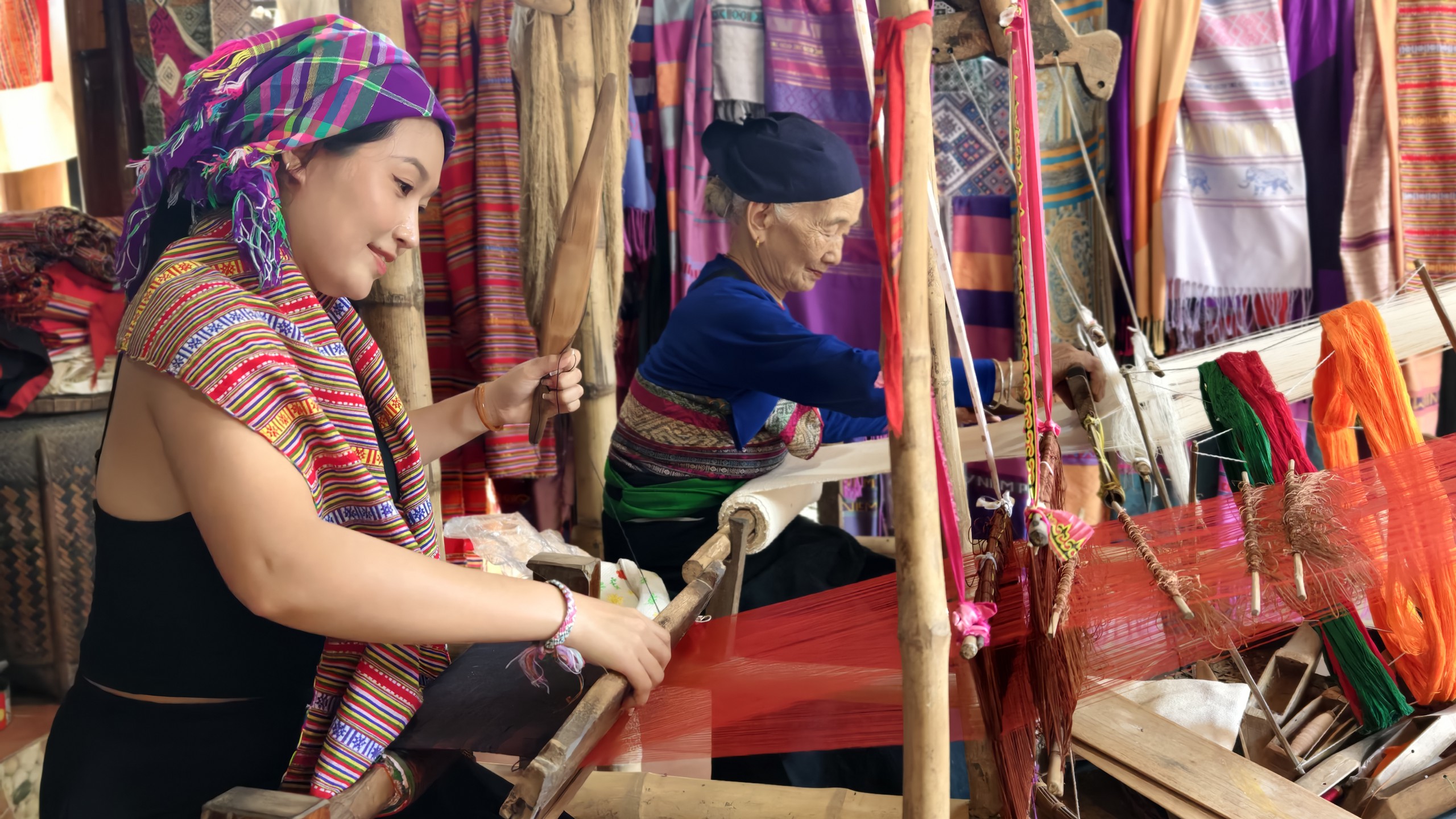 Cụ Hà Thị Nhân hướng dẫn chị Nhân Ái - du khách đến từ TP.HCM dệt vải. Ảnh: Huy Thông - ảnh 4