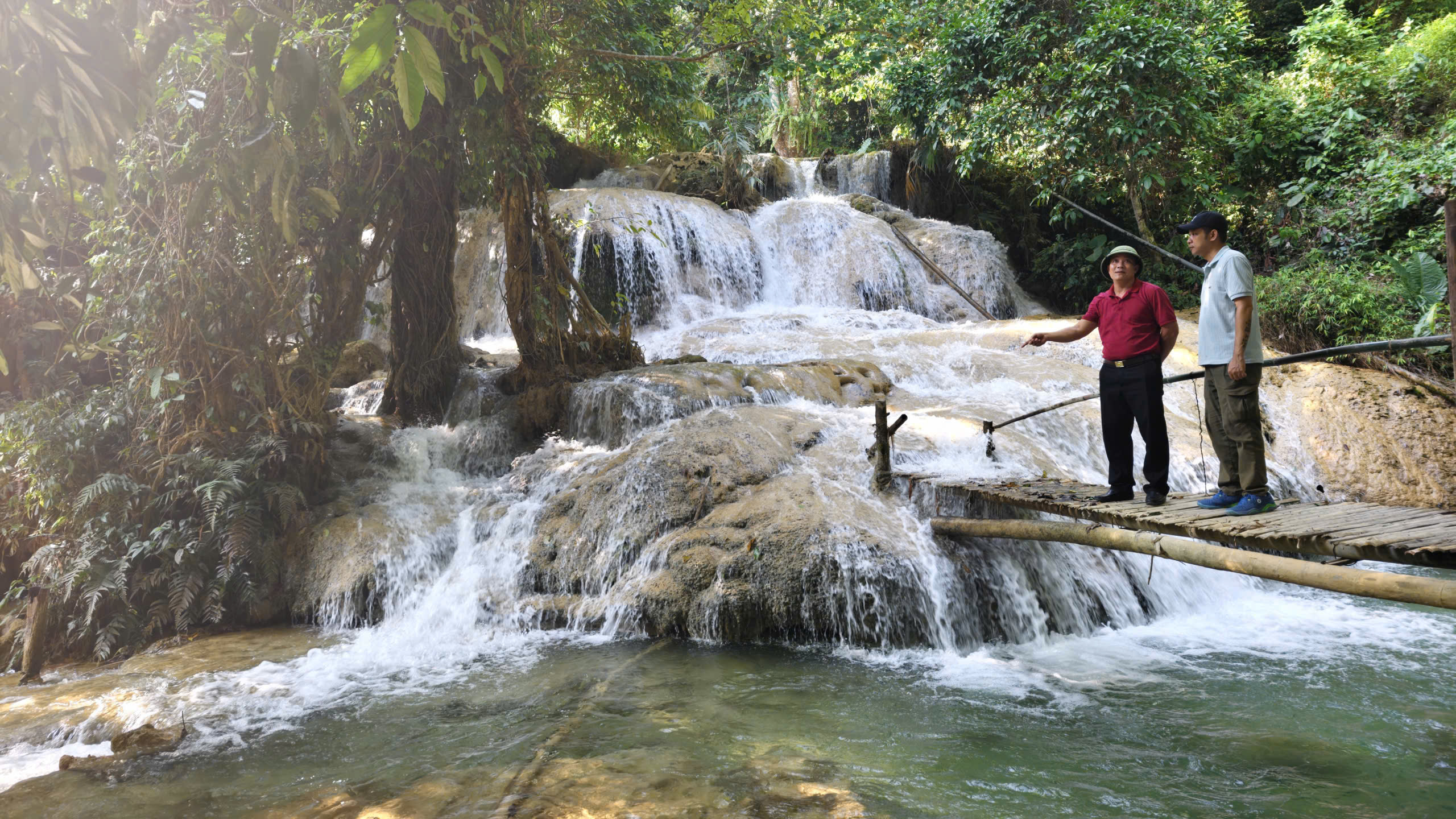 Ông Vi Văn Hùng (áo đỏ bên trái), Phó Trưởng phòng Văn hóa - Xã hội xã Cổ Lũng giới thiệu với phóng viên báo Thể thao và Văn hóa về thác Hiêu. Ảnh: Huy Thông
