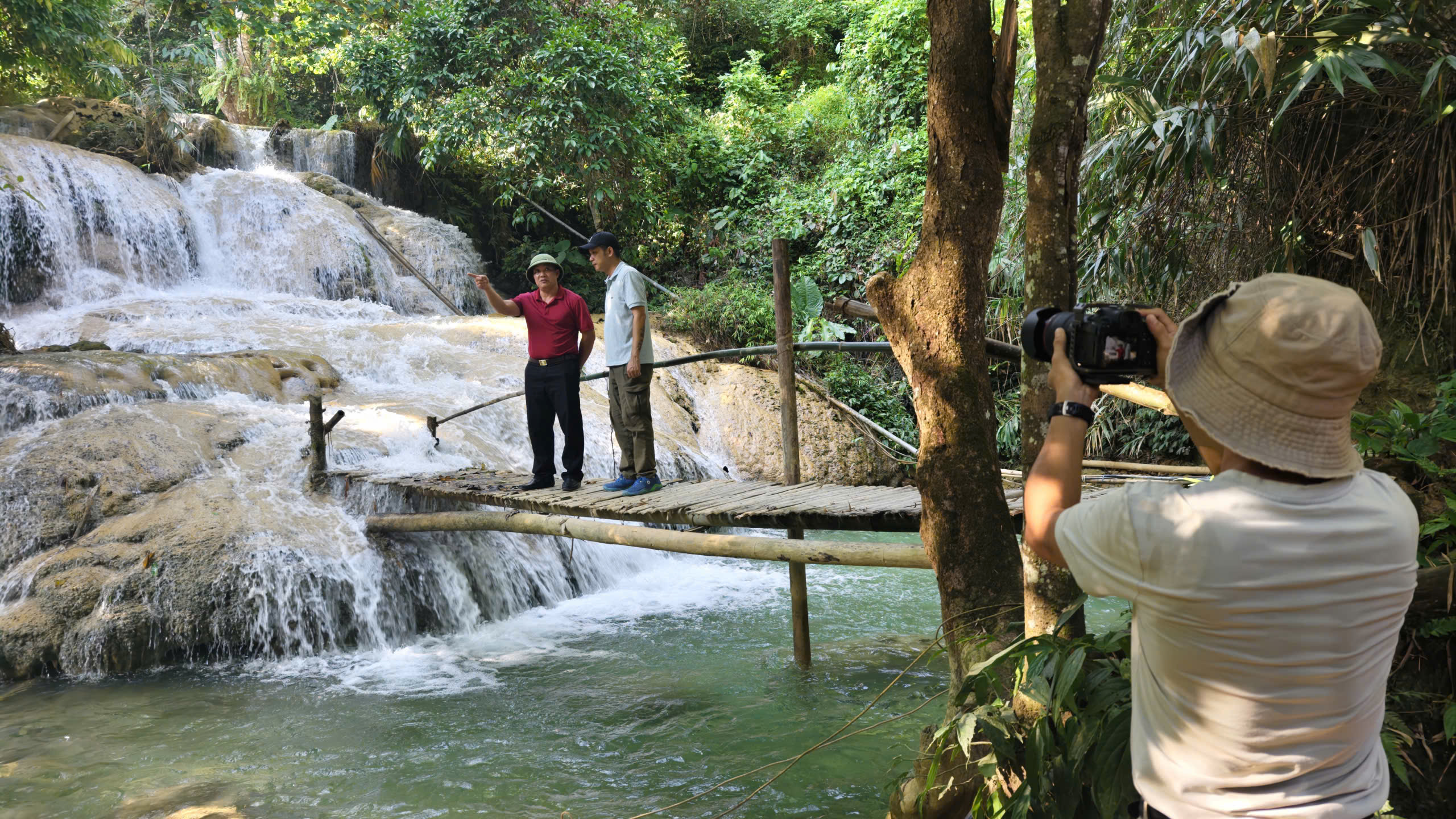 Ông Vi Văn Hùng (áo đỏ bên trái), Phó Trưởng phòng Văn hóa - Xã hội xã Cổ Lũng giới thiệu với phóng viên báo Thể thao và Văn hóa về thác Hiêu. Ảnh: Huy Thông