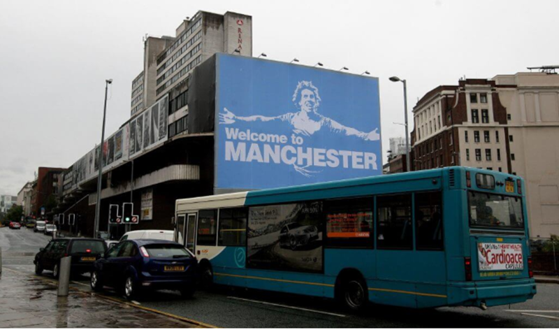 Carlos Tevez và tấm biển "Chào mừng đến Manchester". Ảnh chụp màn hình Carlos Tevez và tấm biển "Chào mừng đến Manchester". Ảnh chụp màn hình