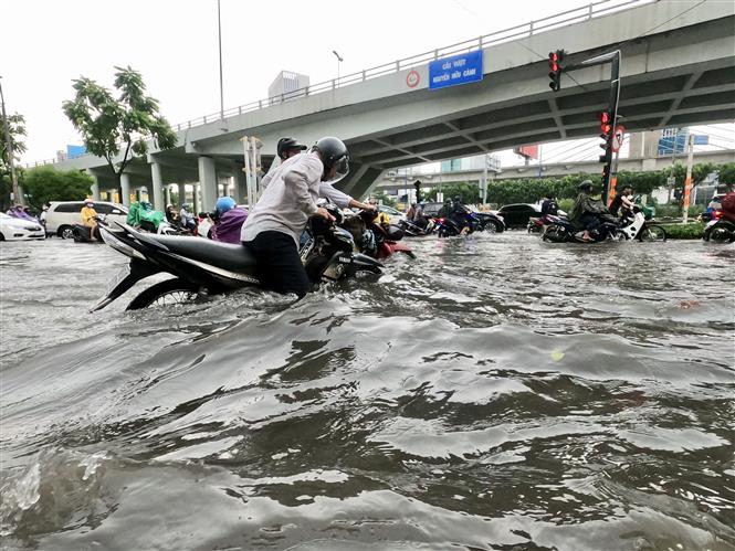 Trong ảnh: Nước ngập nhiều nơi đến hơn nửa mét khiến người dân di chuyển hết sức khó khăn. Ảnh: Hồng Giang - TTXVN