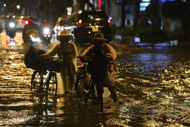 Trong ảnh: Mưa lớn trên đường Lý Thường Kiệt - Phan Bội Châu gây khó khăn cho người tham gia giao thông. Ảnh: Thành Đạt - TTXVN