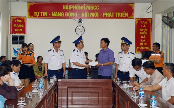 Trong ảnh: Thượng tá Nguyễn Văn Hiển- Phó Chính ủy BTL Vùng Cảnh sát biển 1 trao quà hỗ trợ thân nhân 4 thuyền viên tử nạn. Ảnh: TTXVN