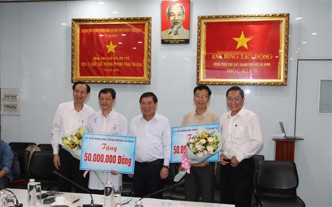 Trong ảnh: Chủ tịch UBND Thành phố Hồ Chí Minh Nguyễn Thành Phong tặng quà động viên cho đại diện Bệnh viện Chợ Rẫy và Bệnh viện Bệnh Nhiệt đới. Ảnh: Đinh Hằng - TTXVN
