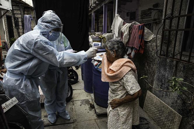 Trong ảnh: Nhân viên y tế kiểm tra thân nhiệt phòng lây nhiễm COVID-19 tại khu nhà ổ chuột ở Mumbai, Ấn Độ. Ảnh: THX/TTXVN