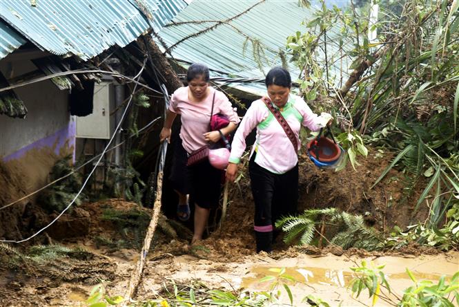 Trong ảnh: Người dân đi lại rất khó khăn do sạt lở đất tại thị xã Sa Pa. Ảnh: Quốc Khánh - TTXVN