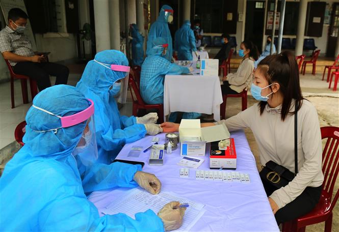 Trong ảnh: Các cán bộ y tế tiến hành xét nghiệm nhanh COVID-19 cho người dân ở thành phố Đông Hà trở về từ vùng có dịch. Ảnh: Hồ Cầu-TTXVN