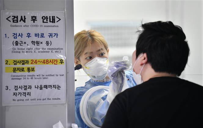  Nhân viên y tế lấy mẫu xét nghiệm COVID-19 cho người dân tại Seoul, Hàn Quốc ngày 18/8/2020. Ảnh: AFP/TTXVN