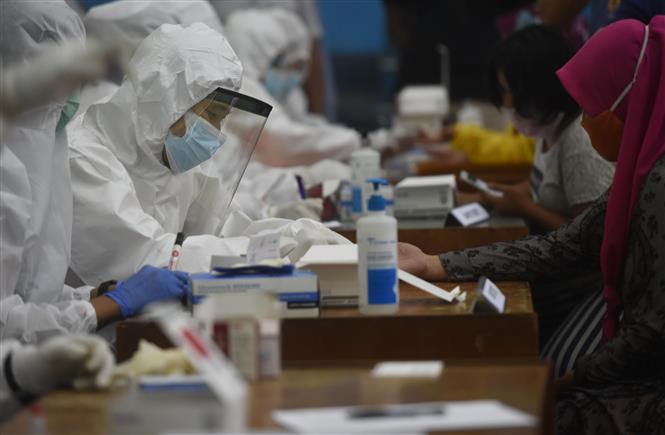 Trong ảnh: Nhân viên y tế lấy mẫu xét nghiệm COVID-19 cho người dân tại Jakarta, Indonesia ngày 23/11/2020. Ảnh: THX/TTXVN