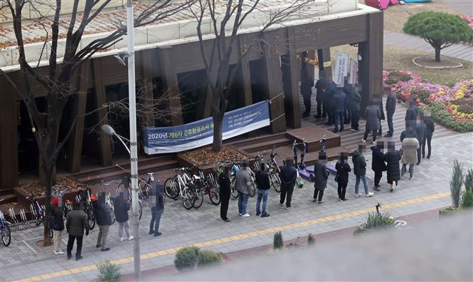 Người dân xếp hàng chờ lấy mẫu xét nghiệm COVID-19 tại Seoul, Hàn Quốc ngày 20/11/2020. Ảnh: Yonhap/TTXVN