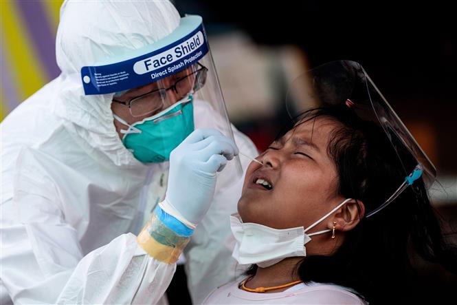 Trong ảnh: Nhân viên y tế lấy mẫu xét nghiệm COVID-19 cho người dân tại Samut Sakhon, Thái Lan, ngày 19/12/2020. Ảnh: AFP/TTXVN