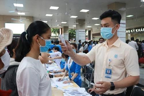 Đo thân nhiệt người đến khám bệnh tại Bệnh viện Đại học Y dược Thành phố Hồ Chí Minh. Ảnh: Đinh Hằng - TTXVN