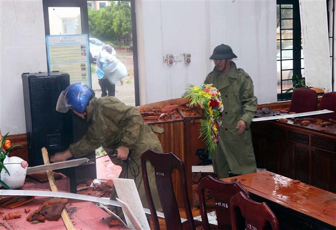 Lực lượng chức năng thu dọn hội trường UBND xã Thịnh Lộc huyện Lộc Hà bị thiệt hại do lốc xoáy. Ảnh: Công Tường-TTXVN