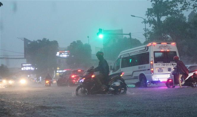 Các phương tiện tham gia giao thông gặp khó khăn do mưa lớn. Ảnh: Nguyễn Oanh-TTXVN.