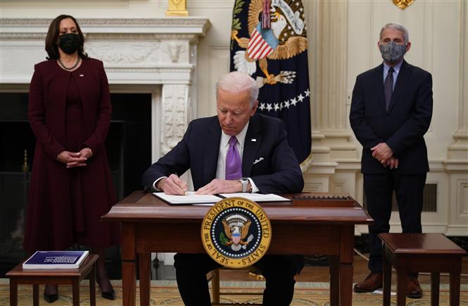 Trong ảnh: Tân Tổng thống Mỹ Joe Biden (giữa) ký các sắc lệnh hành pháp và chỉ thị về ứng phó dịch COVID-19, tại Nhà Trắng, Washington DC., ngày 21/1/2021. Ảnh: AFP/TTXVN