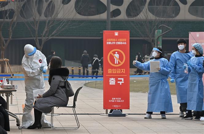 Trong ảnh: Nhân viên y tế lấy mẫu dịch xét nghiệm COVID-19 cho người dân tại Seoul, Hàn Quốc. Ảnh: AFP/ TTXVN