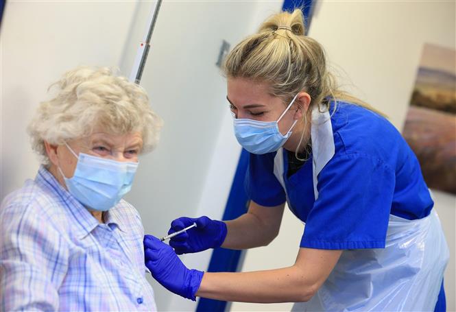 Trong ảnh: Một cụ bà được tiêm vaccine ngừa COVID-19 của Pfizer/BioNTech tại Haxby, Anh ngày 22/12/2020. Ảnh: AFP/TTXVN