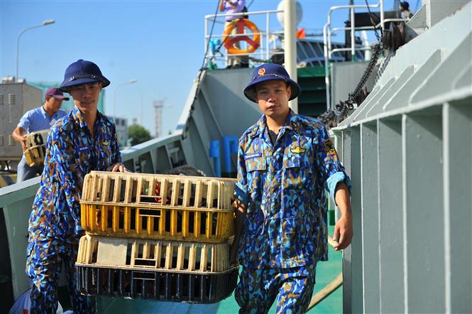 Các chiến sĩ Vùng 2 Hải quân vận chuyển các món quà và nhu yếu phẩm lên tàu để mang ra cho các chiến sĩ ngoài nhà giàn. Ảnh: Minh Đức - TTXVN