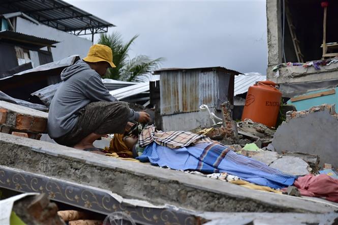 Trong ảnh:Thi thể một nạn nhân thiệt mạng trong trận động đất ở tỉnh Tây Sulawesi , Indonesia, ngày 15/1/2021. Ảnh: AFP/TTXVN