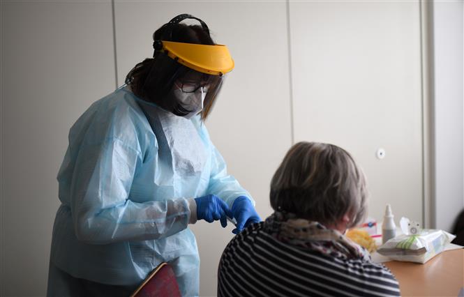 Nhân viên y tế tiêm vaccine phòng COVID-19 của Pfizer-BioNTech cho người dân tại Froendenberg, Đức, ngày 22/2/2021. Ảnh: AFP/ TTXVN