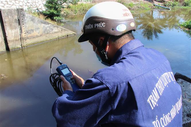  Công nhân vận hành cống kiểm tra độ mặn tại cống Kênh Lầu, xã Hỏa Tiến. Ảnh: Hồng Thái - TTXVN