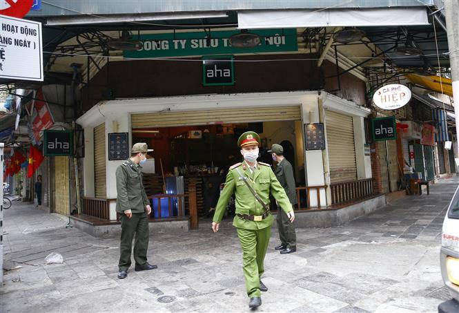  Lực lượng chức năng phường Hàng Mã, quận Hoàn Kiếm đề nghị các hộ kinh doanh thực hiện nghiêm quyết định của Ban chỉ đạo phòng, chống dịch COVID-19 TP Hà Nội. Ảnh: Doãn Tấn - TTXVN