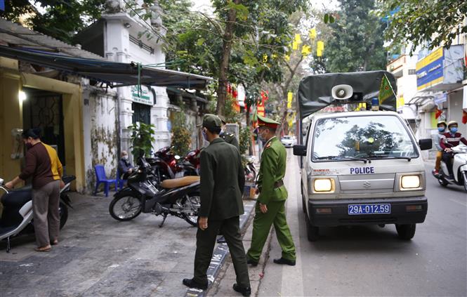 : Lực lượng chức năng phường Hàng Mã, quận Hoàn Kiếm đề nghị các hộ kinh doanh thực hiện nghiêm quyết định của Ban chỉ đạo phòng, chống dịch COVID-19 TP Hà Nội. Ảnh: Doãn Tấn - TTXVN