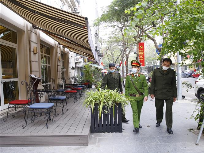  Lực lượng chức năng phường Cửu Nam, quận Hoàn Kiếm đi kiểm tra, nhắc nhở các hộ kinh doanh quán ăn đường phố, trà đá, cà phê đóng cửa. Ảnh: Doãn Tấn - TTXVN