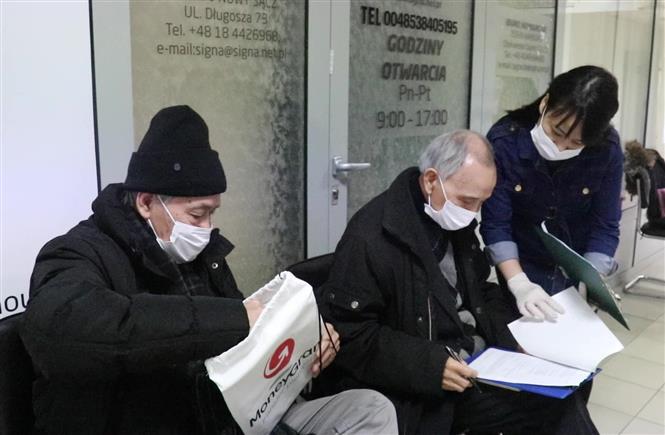 Trong ảnh: Hướng dẫn làm hồ sơ tiêm phòng COVID-19 tại Trung tâm Y tế Lotus, Ba Lan. Ảnh: Văn Long - TTXVN phát