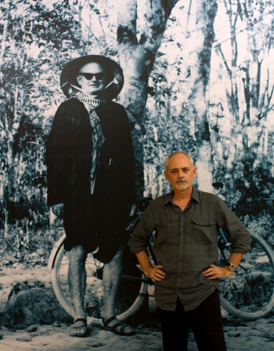 George Burchett  chụp cạnh bức chân dung cha mình – nhà báo Wilfred Burchett- tại Bảo tàng Hồ Chí Minh
