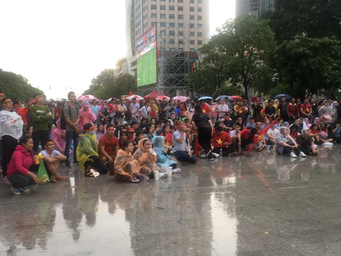 Hàng ngàn CĐV đã đến phố đi bộ Nguyễn Huệ và đội mưa xem U23 Việt Nam thi đấu chiều 29/8. Ảnh: Anh Linh