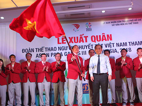 Thứ trưởng Lê Khánh Hải trao cờ xuất quân cho Trưởng đoàn Vũ Thế Phiệt vào sáng 28/9 tại TP.HCM. Ảnh: Trung Huy
