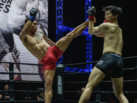 Võ sĩ Trần Quang Lộc (đỏ) giành chiến thắng đầu tiên ở giải đấu MMA. Ảnh: BM