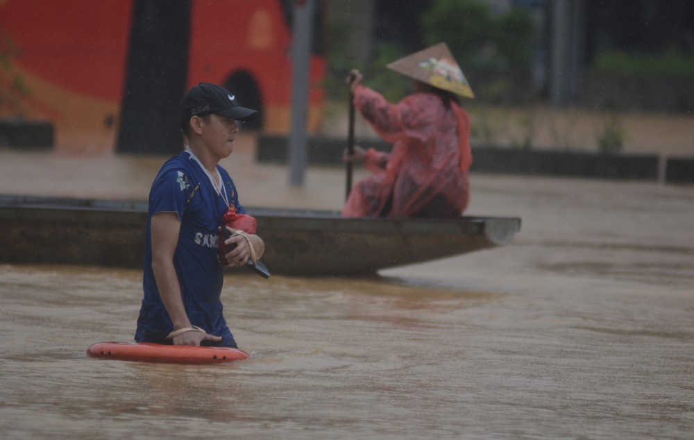 Huế: Người dân khổ sở đi qua vùng nước ngập sâu  - Ảnh 1. Huế: Người dân khổ sở đi qua vùng nước ngập sâu  - Ảnh 1.
