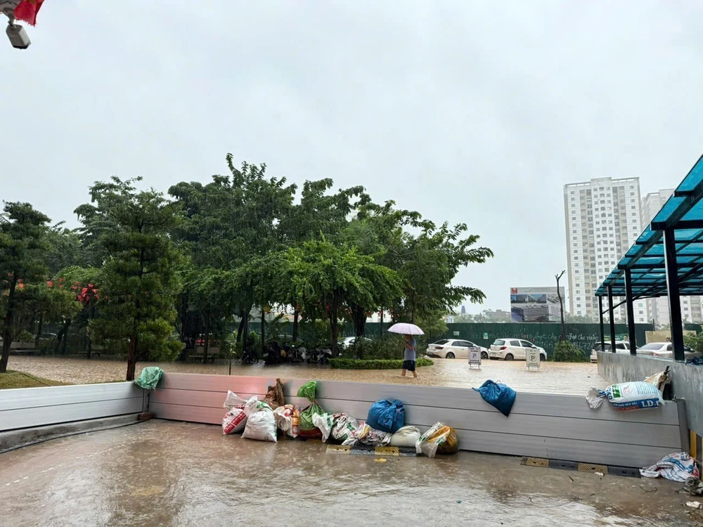 Người Hà Nội dùng bao cát chặn cửa hầm xe, dùng thuyền đi lại quanh khu chung cư - Ảnh 7.