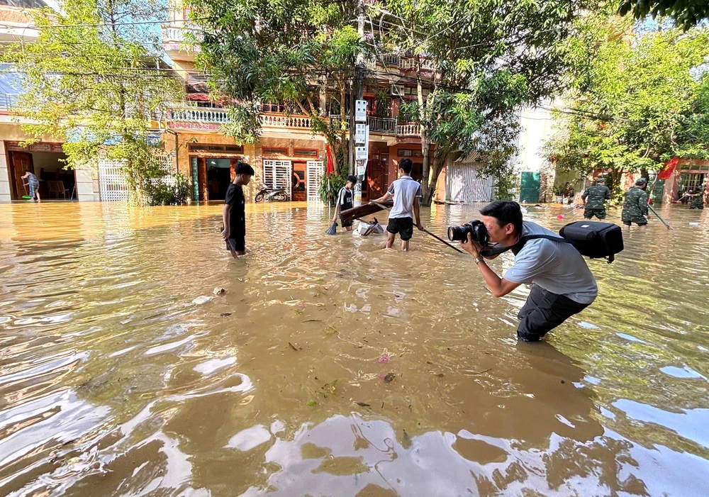 Phóng viên TTXVN có mặt tại tâm lũ, kịp thời chuyển tải thông tin hiện trường - Ảnh 7. Phóng viên TTXVN có mặt tại tâm lũ, kịp thời chuyển tải thông tin hiện trường - Ảnh 7.