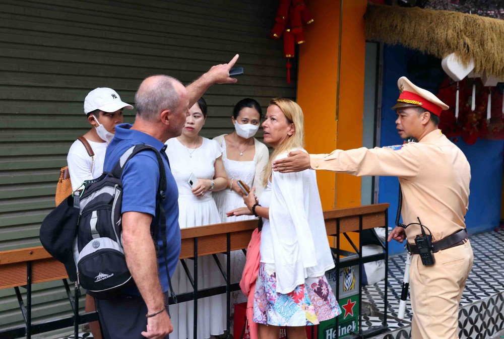 Cảnh sát giao thông tuyên truyền, nhắc nhở vi phạm tại khu &quot;cà phê đường tàu&quot; ở Hà Nội - Ảnh 1.