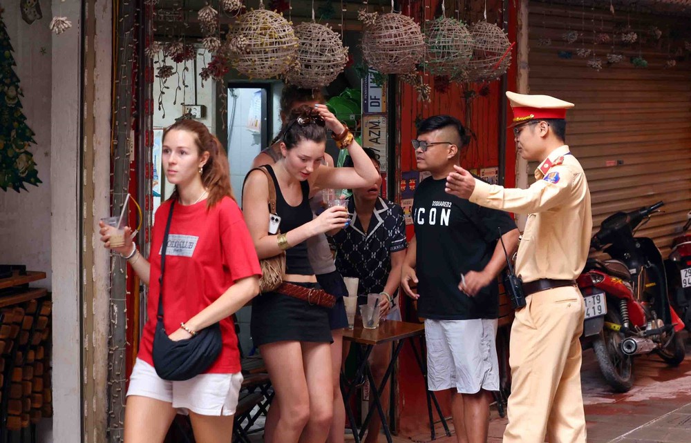 Cảnh sát giao thông tuyên truyền, nhắc nhở vi phạm tại khu &quot;cà phê đường tàu&quot; ở Hà Nội - Ảnh 4.