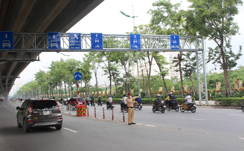 Nhiều xe máy vẫn lấn làn trên đường Phạm Văn Đồng (Hà Nội) - Ảnh 1.