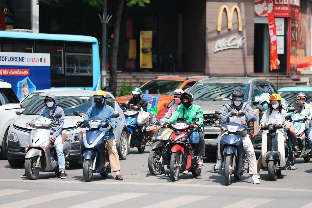 Người dân Hà Nội chống chọi với nắng nóng gay gắt đầu tháng 7 - Ảnh 2.