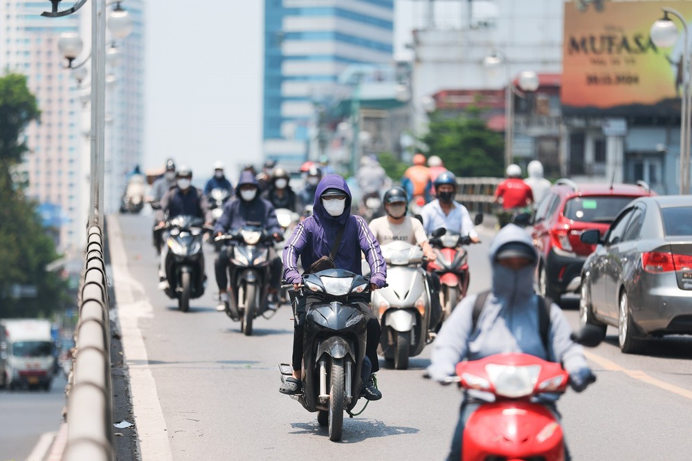Người dân Hà Nội chống chọi với nắng nóng gay gắt đầu tháng 7 - Ảnh 1.