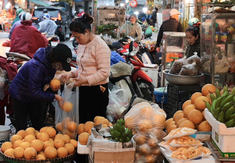 Người dân Hà Nội đội mưa rét đi chợ sớm sắm lễ cúng ông Công, ông Táo - Ảnh 7.