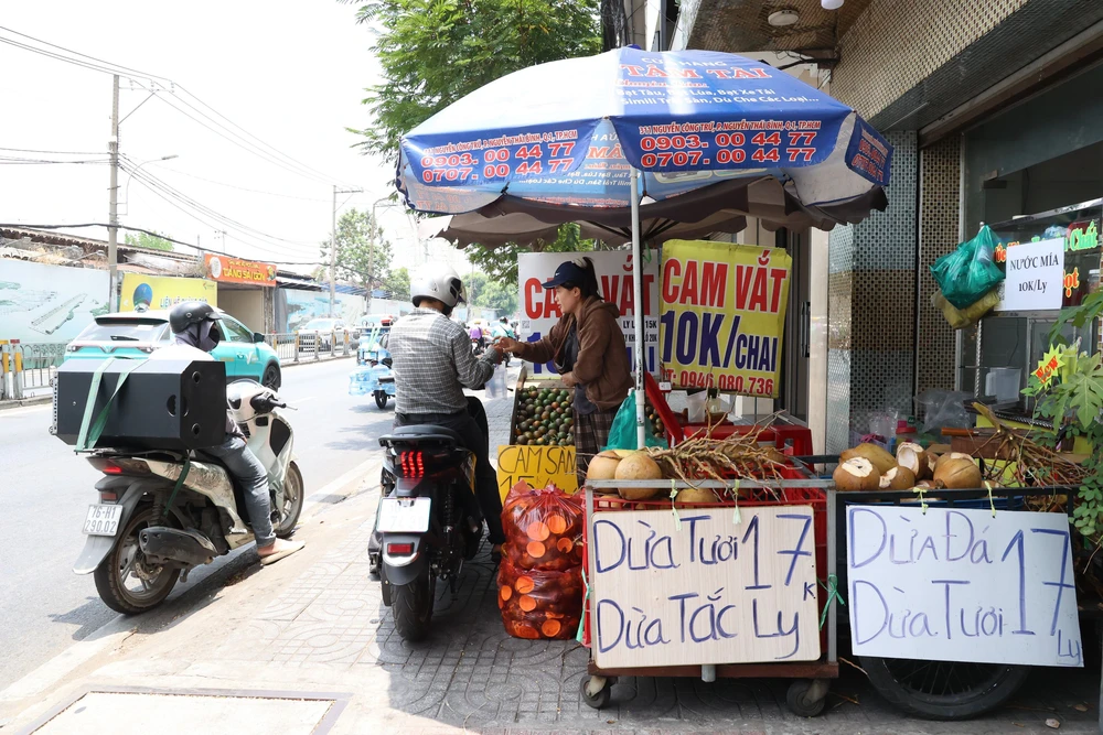 Người dân xoay sở dưới nắng nóng cao điểm ở Thành phố Hồ Chí Minh - Ảnh 2. Người dân xoay sở dưới nắng nóng cao điểm ở Thành phố Hồ Chí Minh - Ảnh 2.