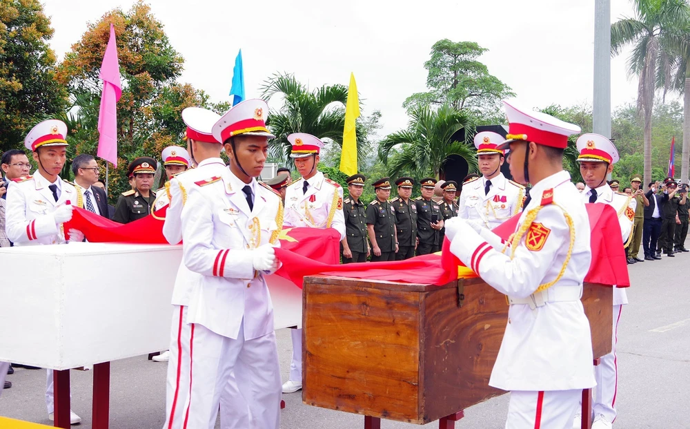 Lễ đón nhận 28 hài cốt liệt sĩ quân tình nguyện và chuyên gia Việt Nam hy sinh tại Lào - Ảnh 3.
