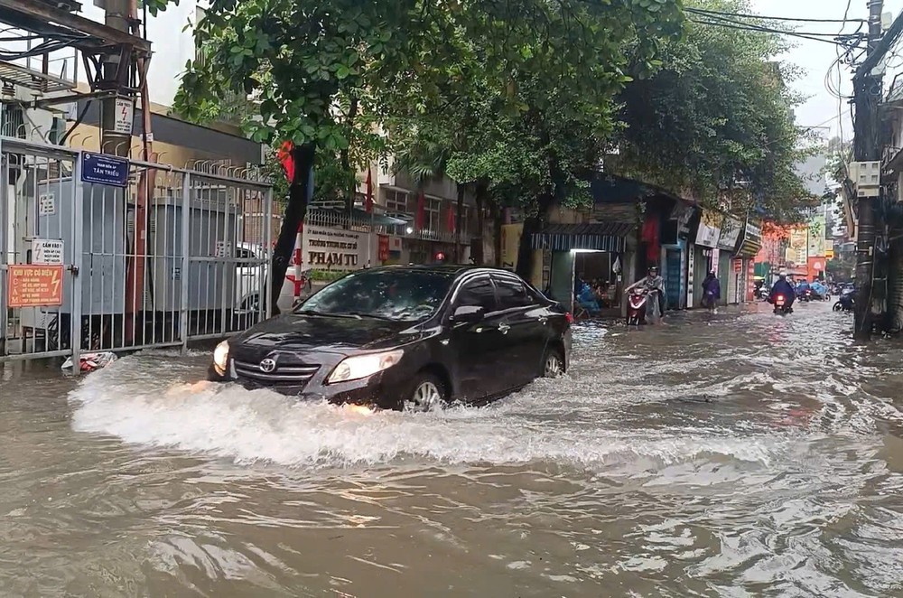 Cảnh sát giao thông Hà Nội phân luồng tại các điểm ngập do mưa lớn - Ảnh 1. Cảnh sát giao thông Hà Nội phân luồng tại các điểm ngập do mưa lớn - Ảnh 1.